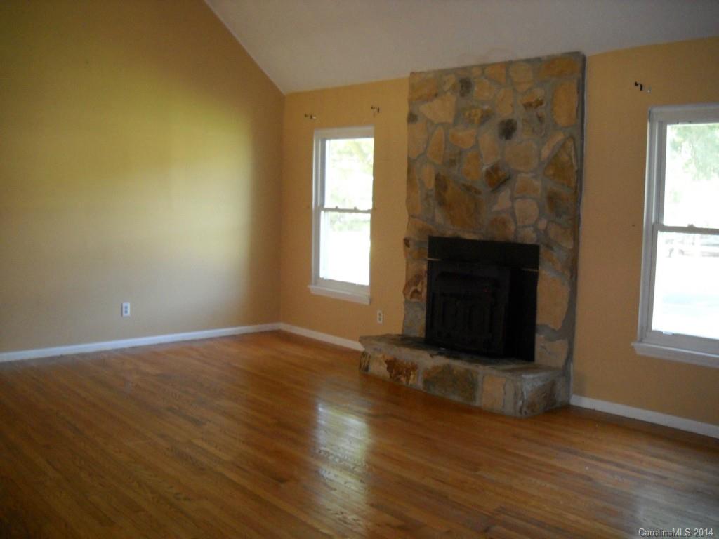11405 Park Road Charlotte, NC 28226 - Photo 3 of 19 a view of empty room with wooden floor and fireplace