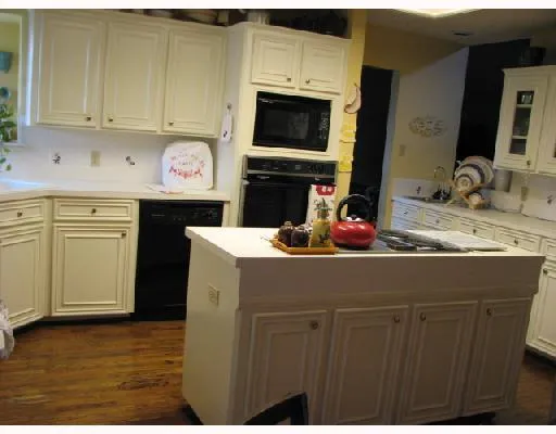 a kitchen with a sink dishwasher stove and cabinets