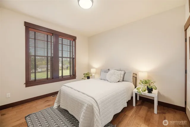 a bedroom with a bed and wooden floor