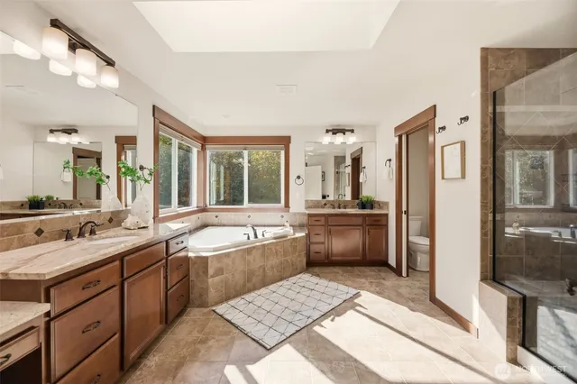 a large bathroom with a double vanity sink a large mirror and a bathtub