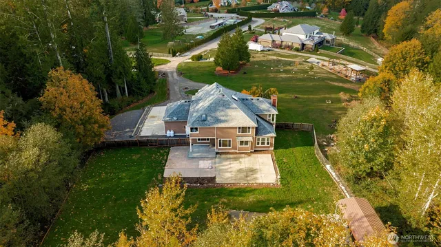 an aerial view of a house with a big yard and large trees