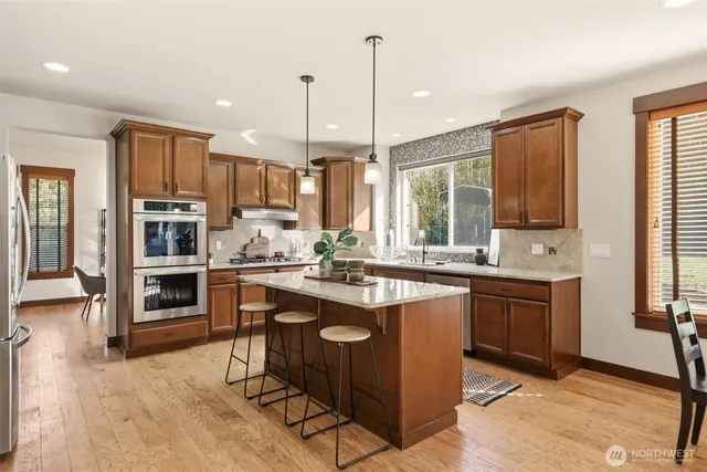a kitchen with kitchen island granite countertop a sink counter top space appliances and cabinets