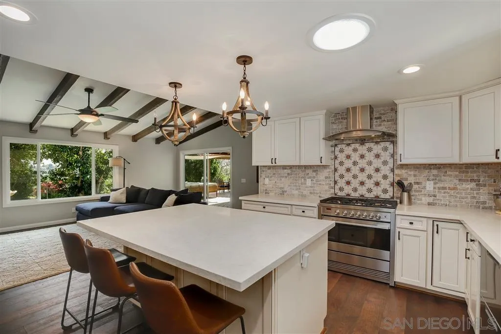 1285 Palomino Road Fallbrook, CA 92028 - Photo 1 of 25 a kitchen with a stove a white cabinets and chairs