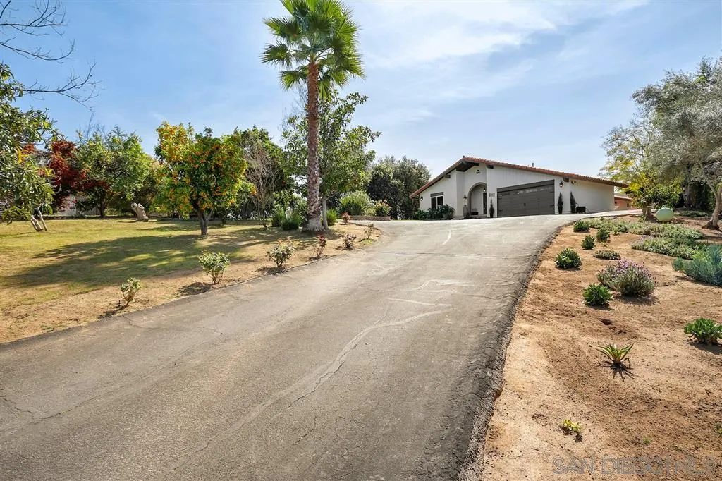 1285 Palomino Road Fallbrook, CA 92028 - Photo 2 of 25 a front view of a house with a yard and trees