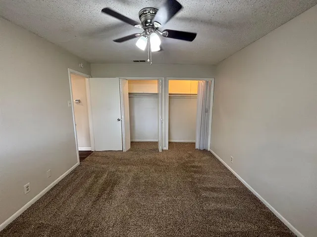 a view of a bedroom with a ceiling fan and a chandelier fan