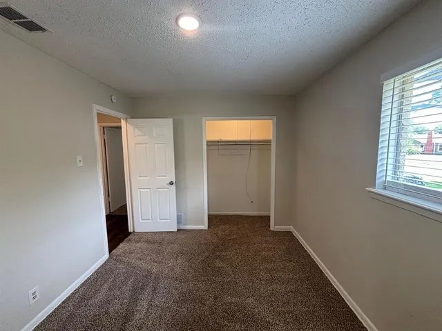 an empty room with windows and closet