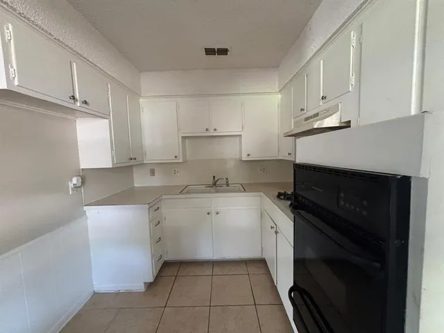 a kitchen with a sink stove and cabinets