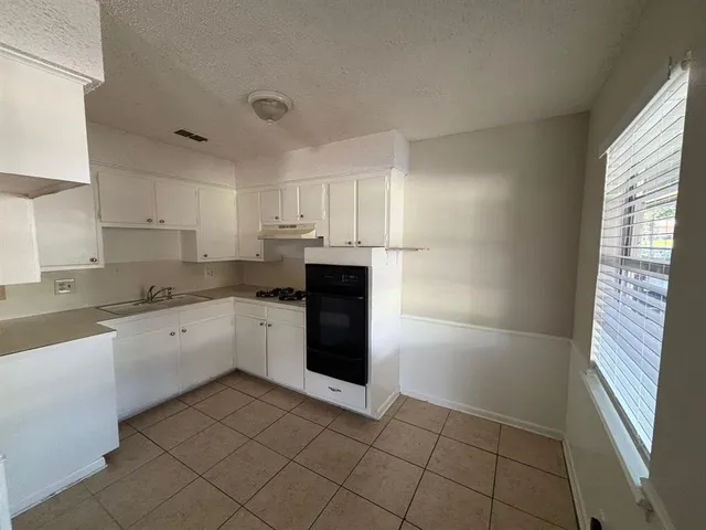 a kitchen with a sink a refrigerator and cabinets