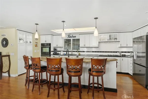 a kitchen with stainless steel appliances a stove a sink a refrigerator and cabinets