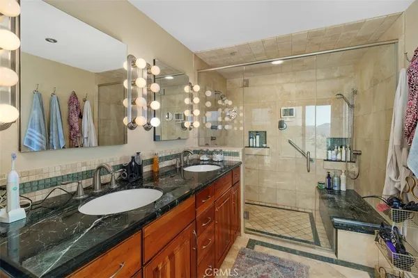 a bathroom with a granite countertop sink mirror and bathtub