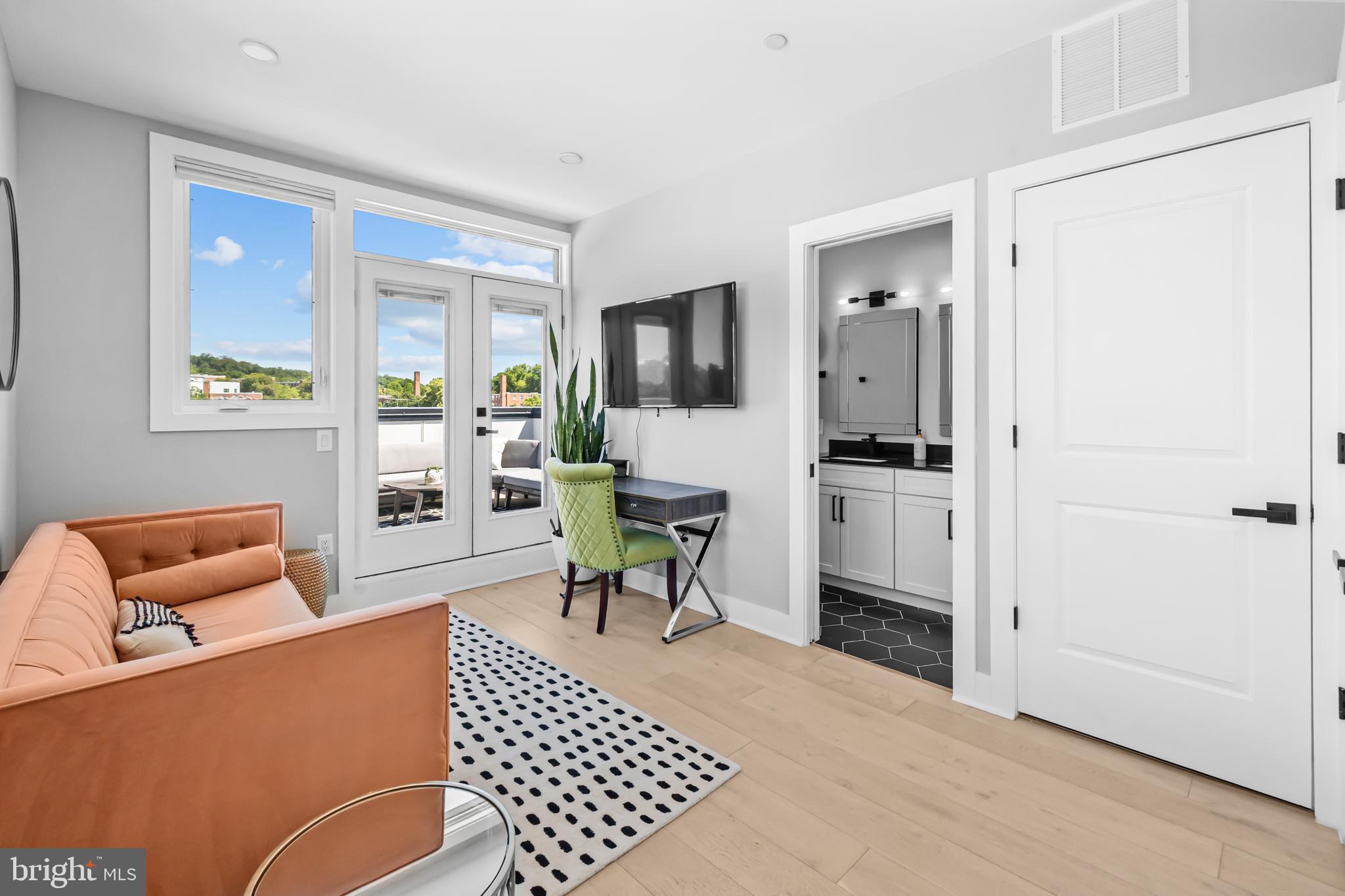 1915 H Street Northeast, Unit PH1 Washington, DC 20002 - Photo 2 of 21 a living room with furniture and a flat screen tv