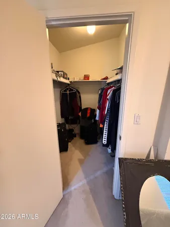 a view of walk in closet with clothes and shoes