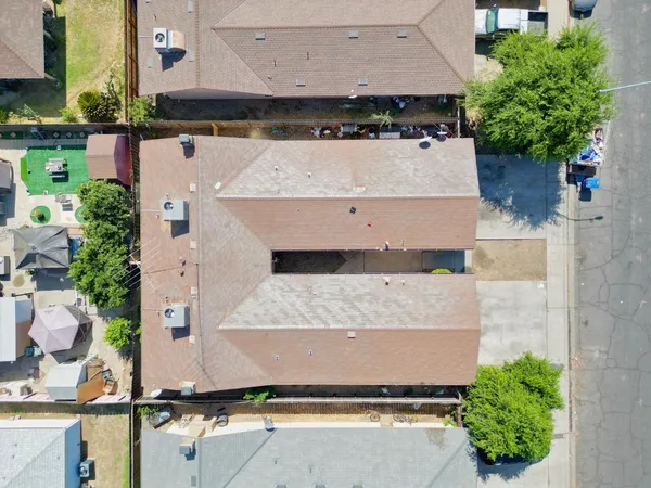 an aerial view of a house with a yard and a large tree