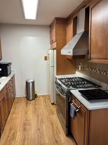 a kitchen with granite countertop a stove and a wooden floor