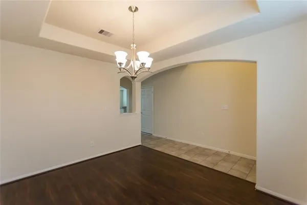 a view of a chandelier with wooden floor and chandelier