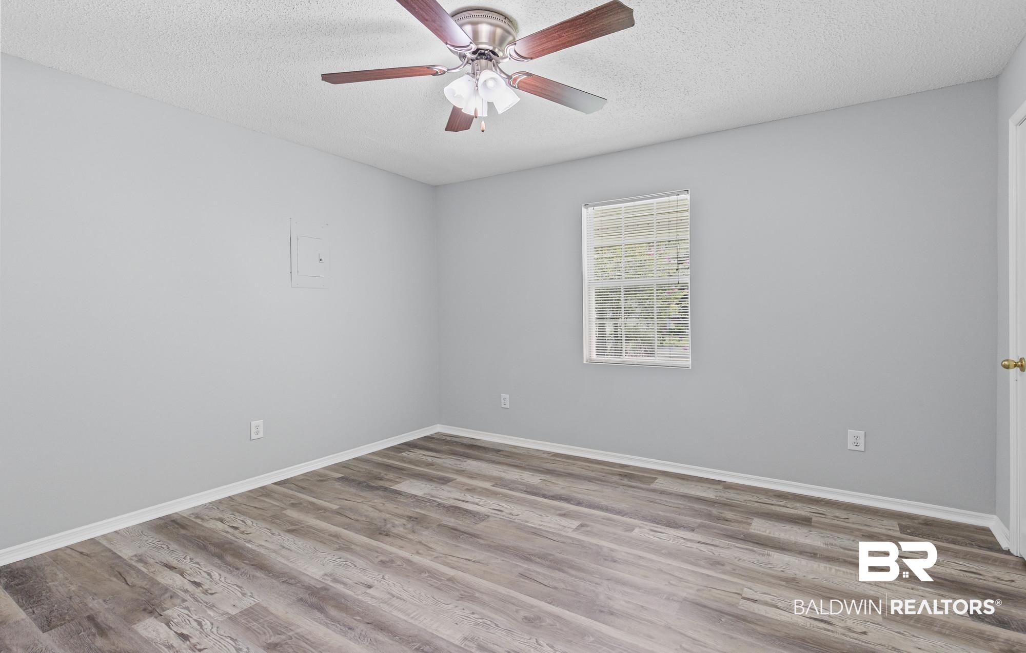 6933 Burbank Court Mobile, AL 36619 - Photo 18 of 25 Spacious room featuring wood-finish flooring, a window with blinds, and light-toned walls
