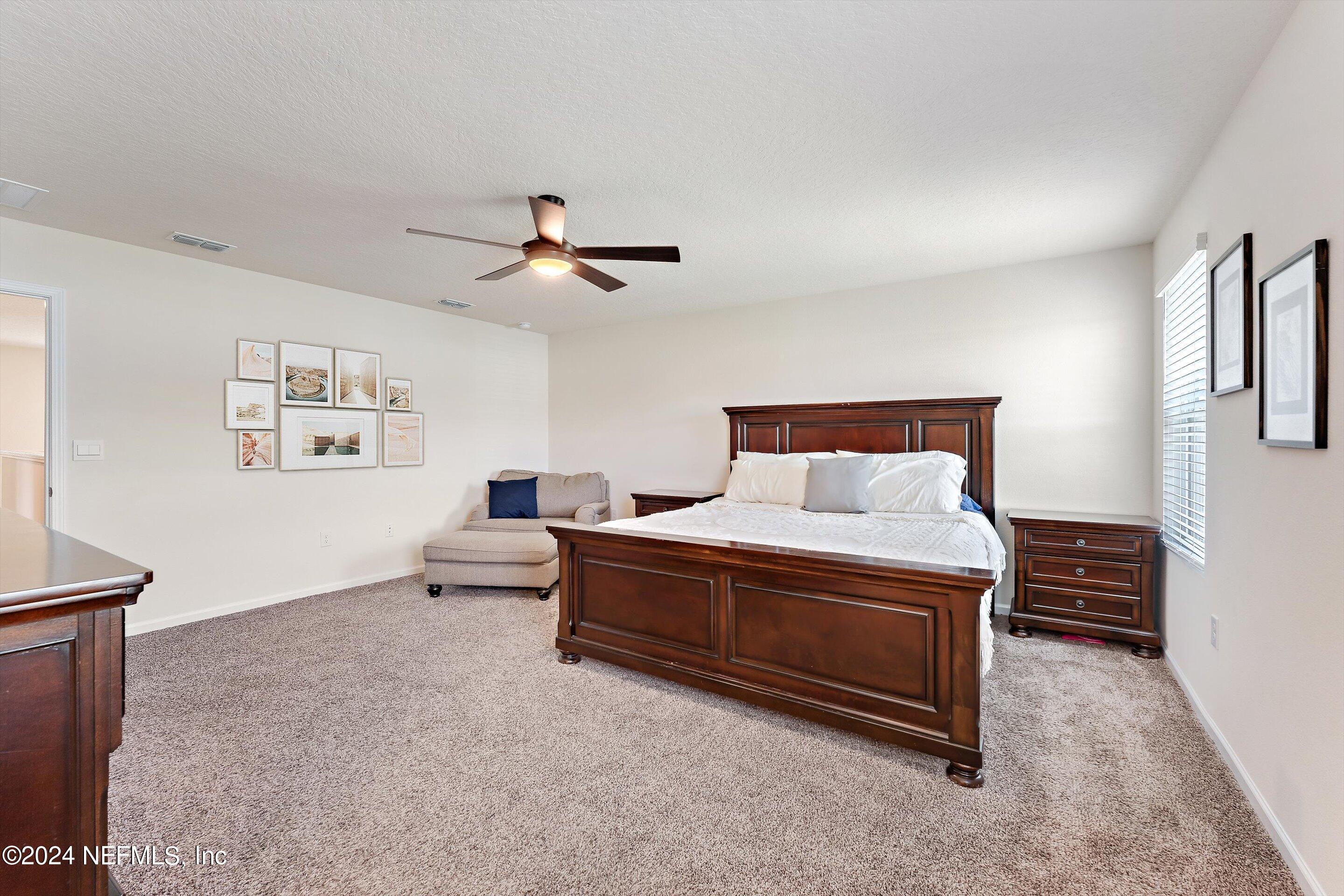 198 Caminha Road St. Augustine, FL 32084 - Photo 17 of 43 a spacious bedroom with a bed and a chandelier