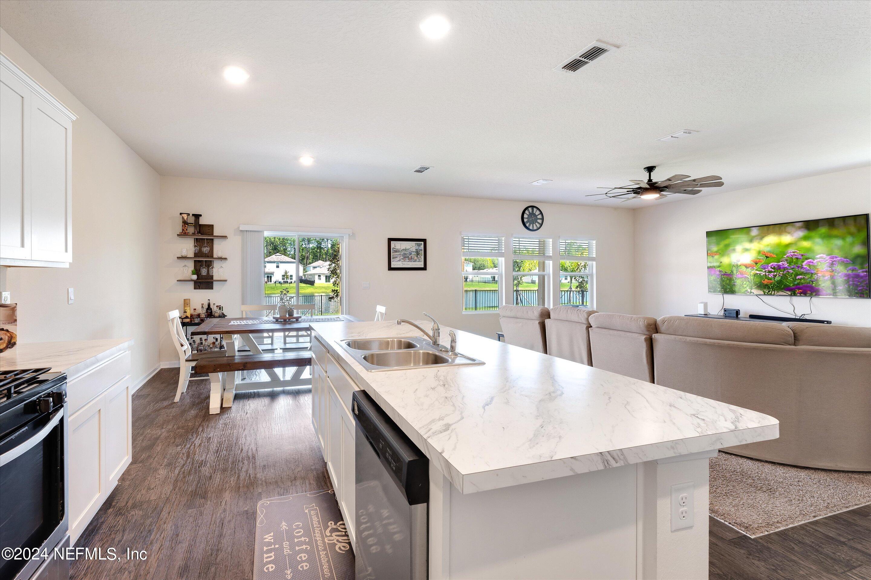 198 Caminha Road St. Augustine, FL 32084 - Photo 6 of 43 a kitchen with a stove a sink dishwasher and a dining table with garden view