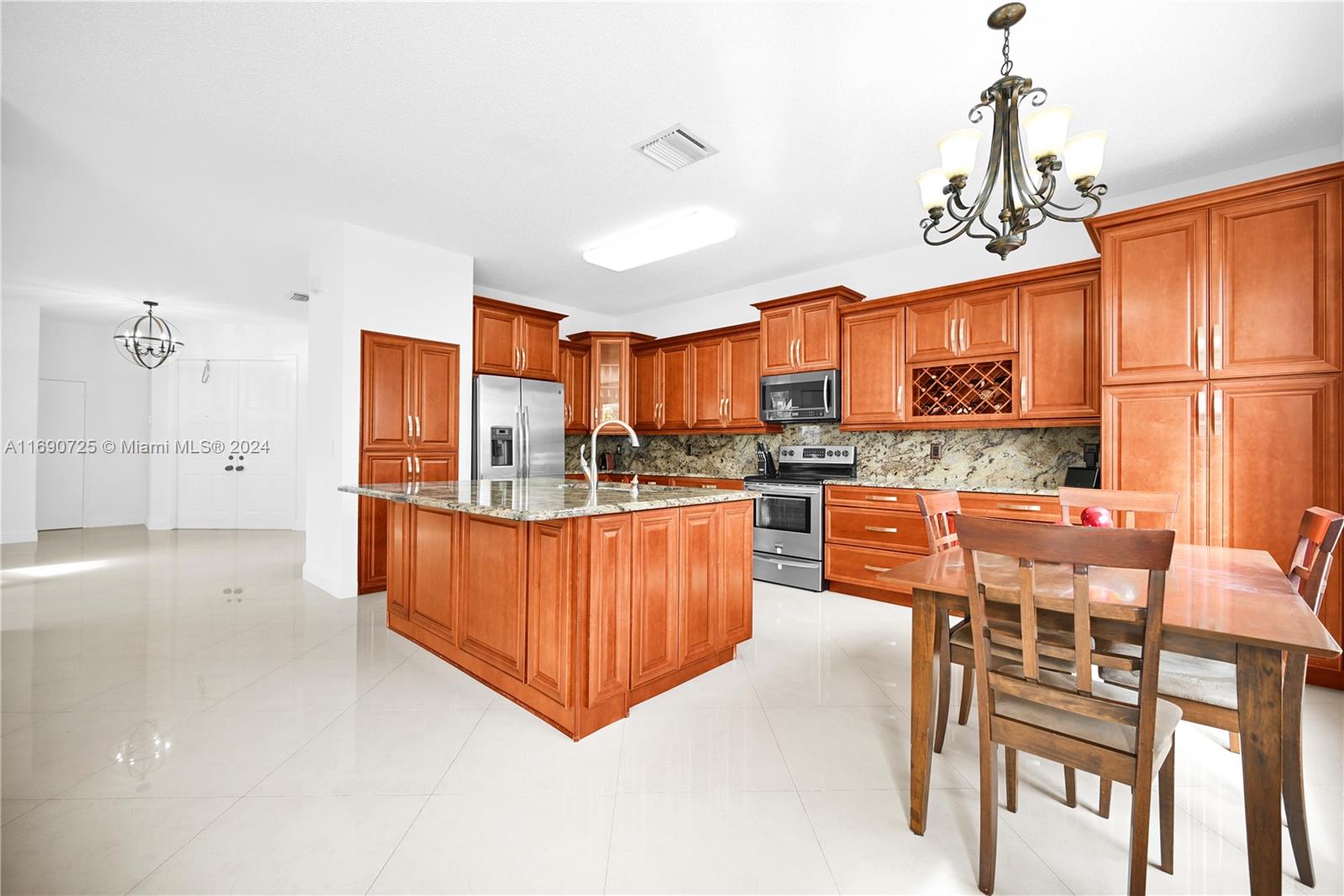 2497 Southwest 163rd Avenue Miramar, FL 33027 - Photo 8 of 50 a kitchen with stainless steel appliances granite countertop a refrigerator and a stove top oven