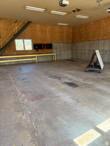 4458 East Glencoe Road Preston, ID 83263 - Photo 43 of 46 Concrete flooring with built-in workbench, wall-mounted electrical outlets, and overhead fluorescent lighting fixtures