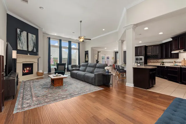 a living room with furniture a fireplace and a kitchen view
