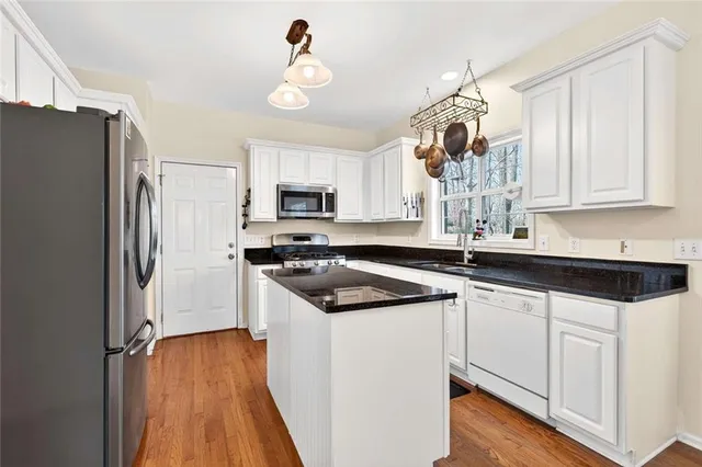a kitchen with granite countertop a sink stove and refrigerator