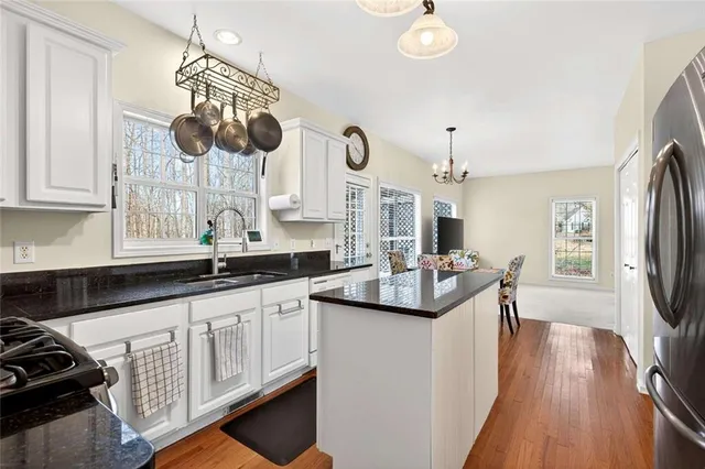 a kitchen with granite countertop a sink a stove and cabinets