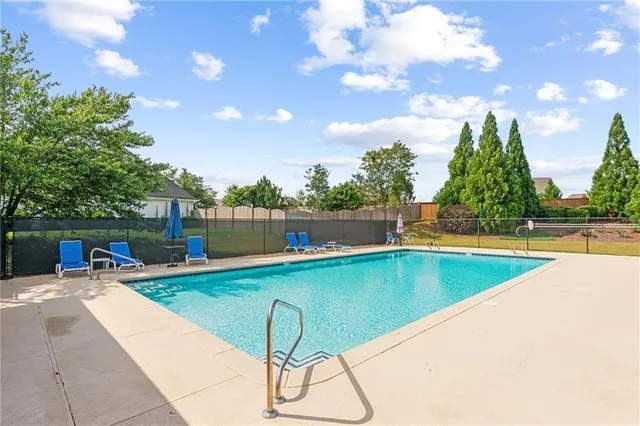 a view of a swimming pool with a lounge chair and floor to ceiling window