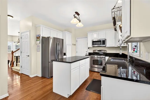 a kitchen with stainless steel appliances a refrigerator stove and wooden floor