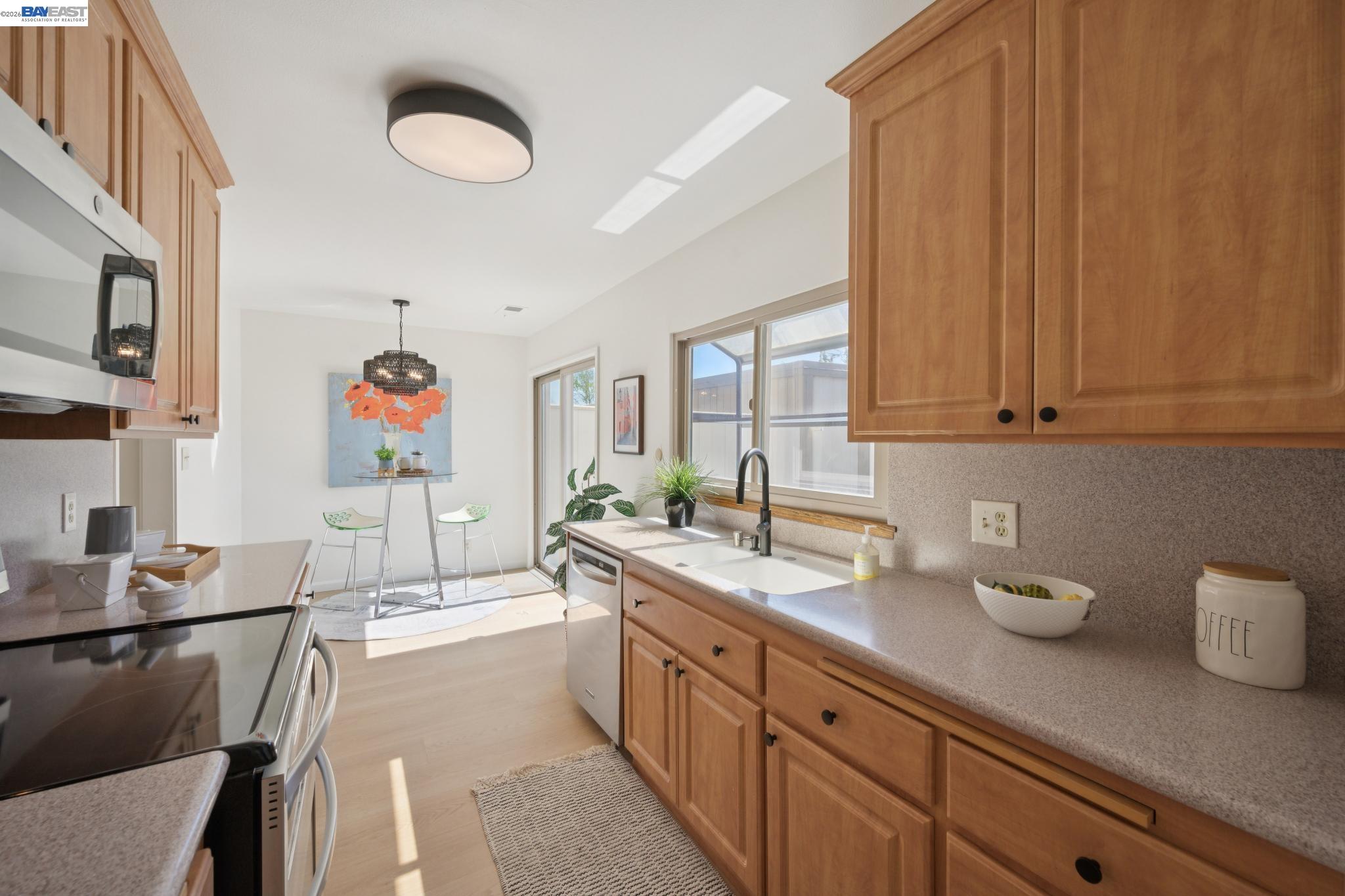 3201 Phoenix Lane Alameda, CA 94502 - Photo 13 of 58 a spacious bathroom with stainless steel appliances granite countertop a sink dishwasher and cabinets with wooden floor