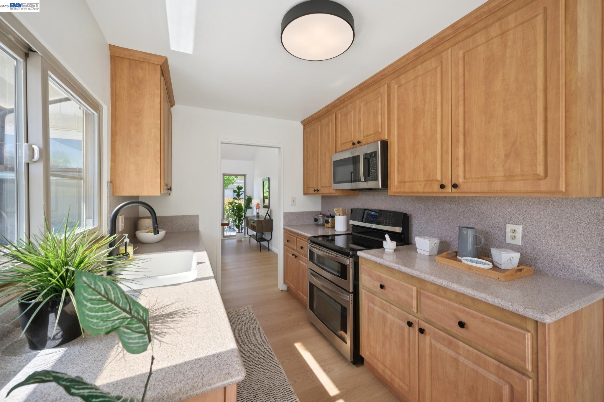 3201 Phoenix Lane Alameda, CA 94502 - Photo 17 of 58 a kitchen with stainless steel appliances granite countertop a stove a sink dishwasher and a microwave oven with white cabinets