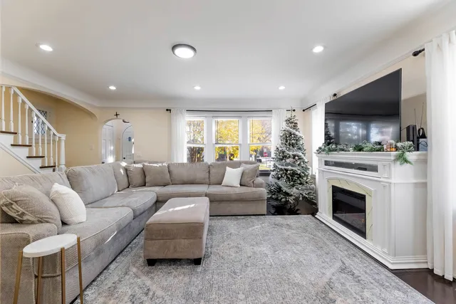 a living room with furniture a flat screen tv and a fireplace