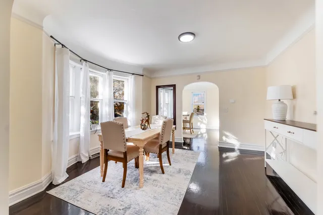 a view of a a dining room with furniture window and wooden floor
