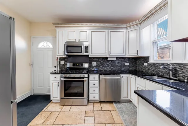 a kitchen with stainless steel appliances granite countertop a stove a microwave and a sink