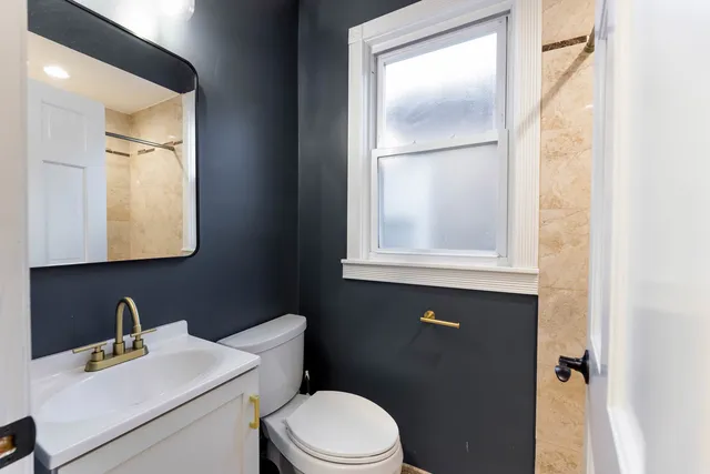 a bathroom with a sink vanity mirror and toilet