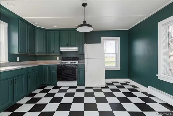 a kitchen with a checkered floor and white cabinets