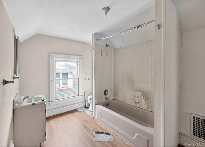 63 Rugby Avenue Rochester, NY 14619 - Photo 21 of 23 a bathroom with a tub a sink and a window