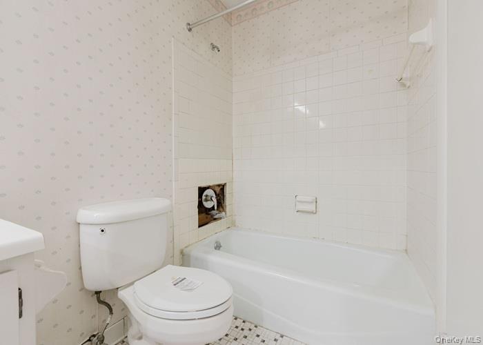 63 Rugby Avenue Rochester, NY 14619 - Photo 22 of 23 a white toilet sitting next to a bath tub