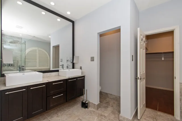 a bathroom with a granite countertop sink a mirror and a shower
