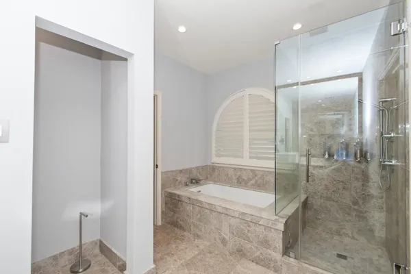 a bathroom with a granite countertop bathtub shower and sink
