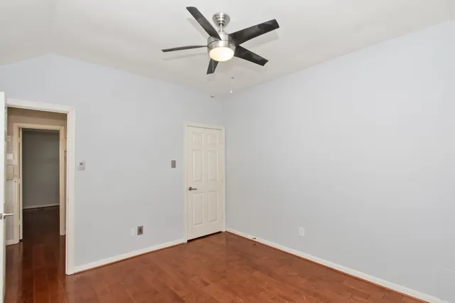 an empty room with closet and fan