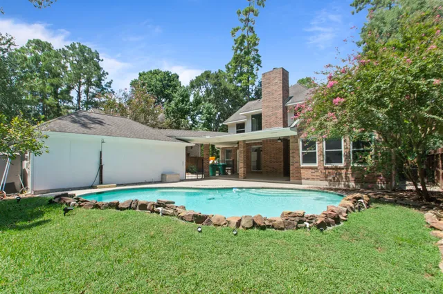 a front view of a house with a garden and trees