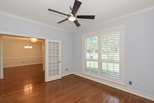 a view of an empty room with wooden floor and a window