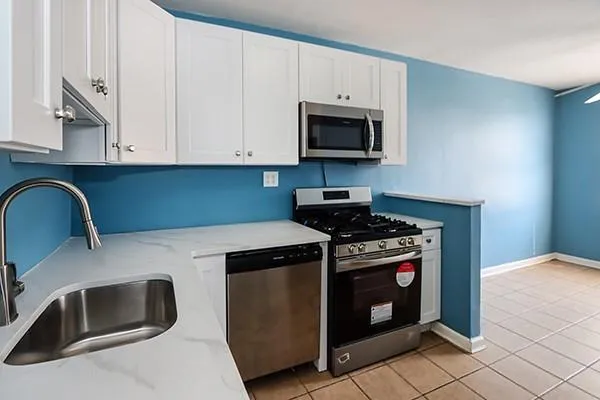 a kitchen with granite countertop white cabinets and stainless steel appliances