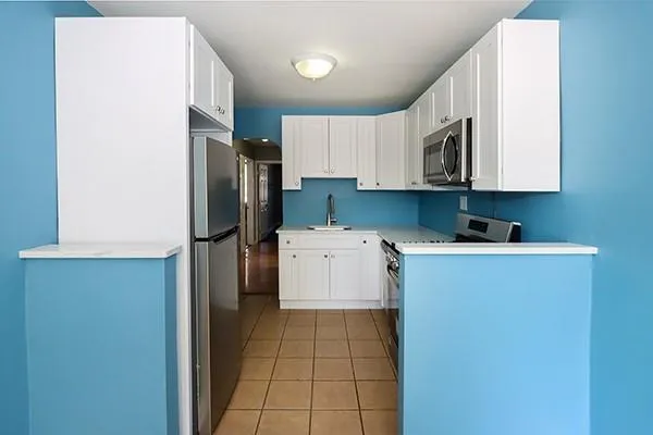 a kitchen with a refrigerator sink stove and cabinets