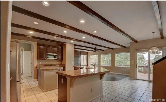 a kitchen with stainless steel appliances granite countertop a refrigerator a sink and a stove