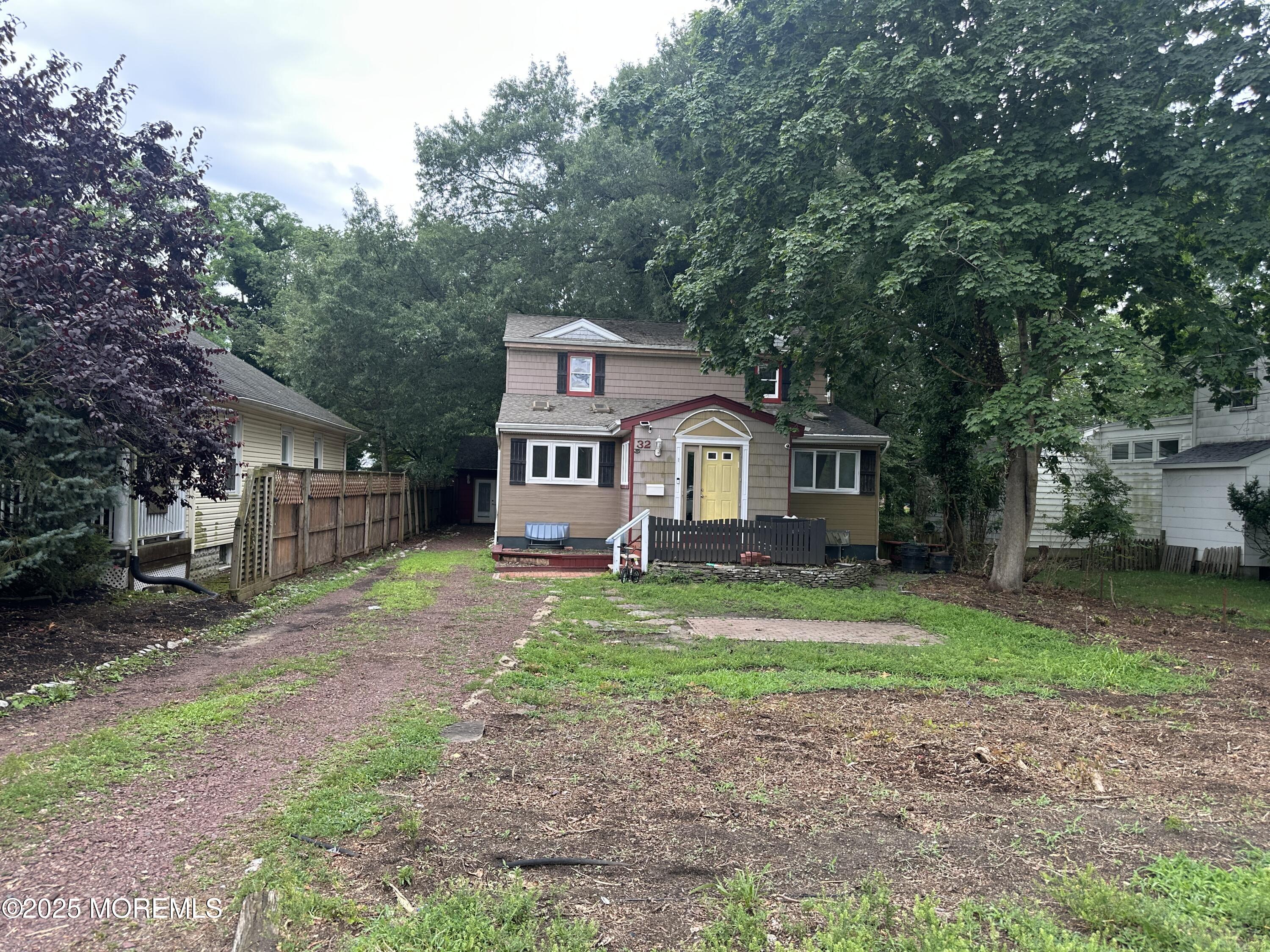 32 Woodrow Street Oakhurst, NJ 07755 - Photo 3 of 19 a front view of a house with a yard and garage