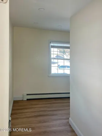 a view of empty room with wooden floor
