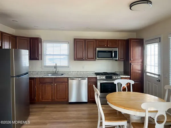 a kitchen with granite countertop a stove a sink dishwasher a refrigerator and a microwave