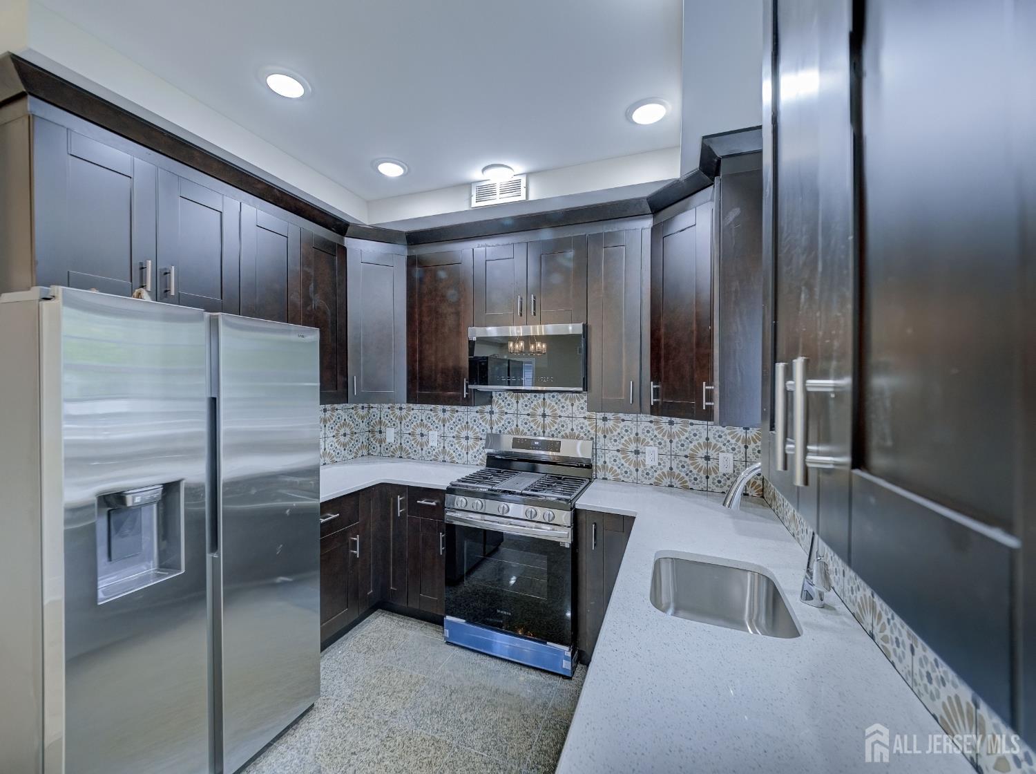 8 Travers Avenue, Unit 1 Edison, NJ 08817 - Photo 6 of 19 a kitchen with stainless steel appliances granite countertop a refrigerator and a sink